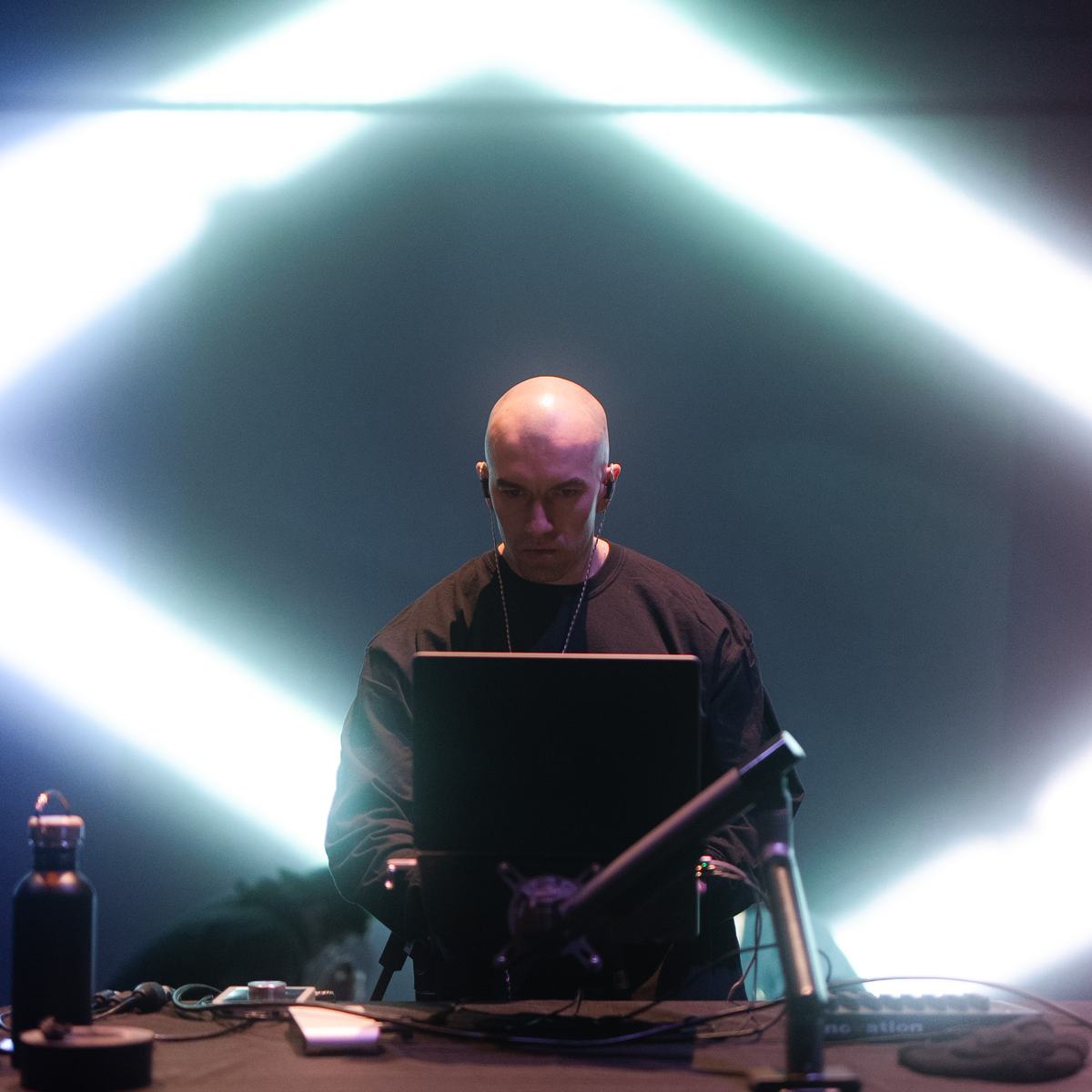 Factor Eight at the desk under a projected diamond of light