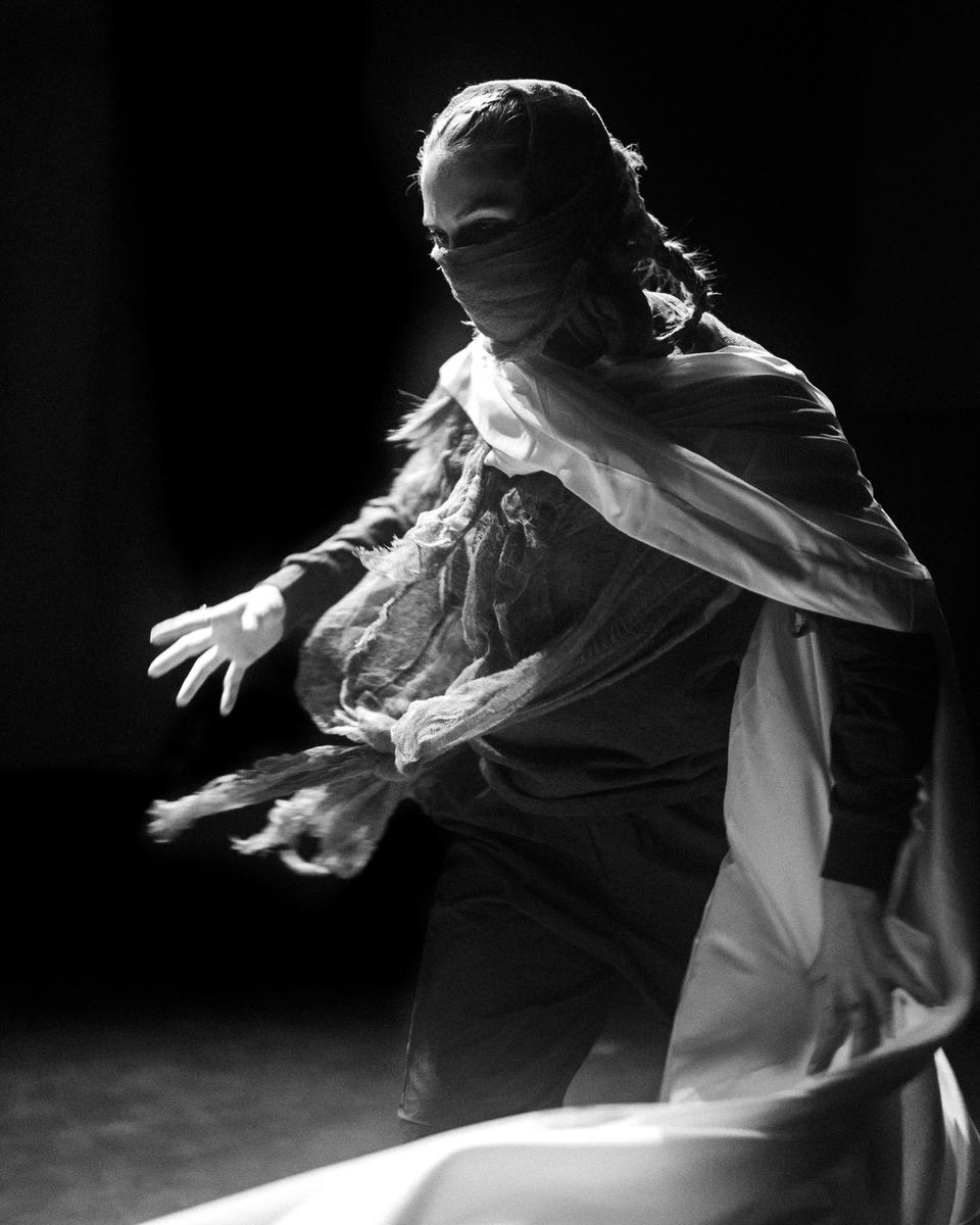 A dancer moving in white fabric