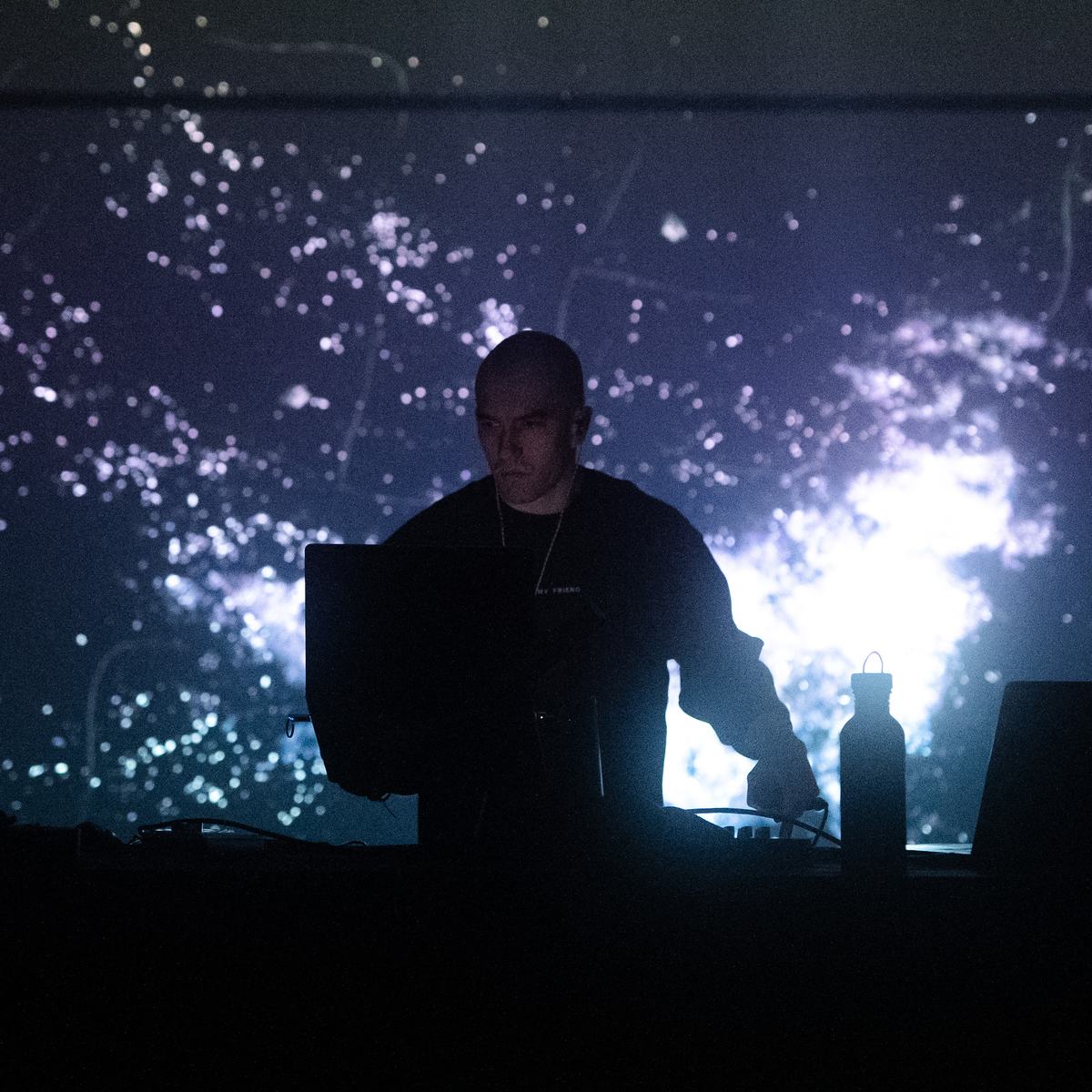 Factor Eight at the desk in front of projected light