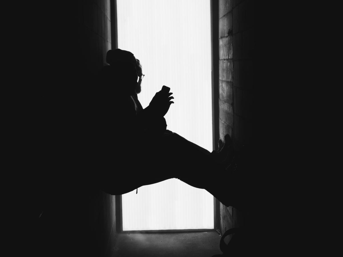 A visitor sitting at the edge of the light