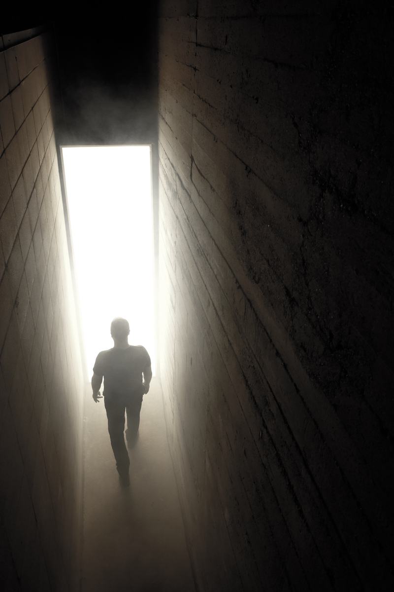 A visitor walking toward the light