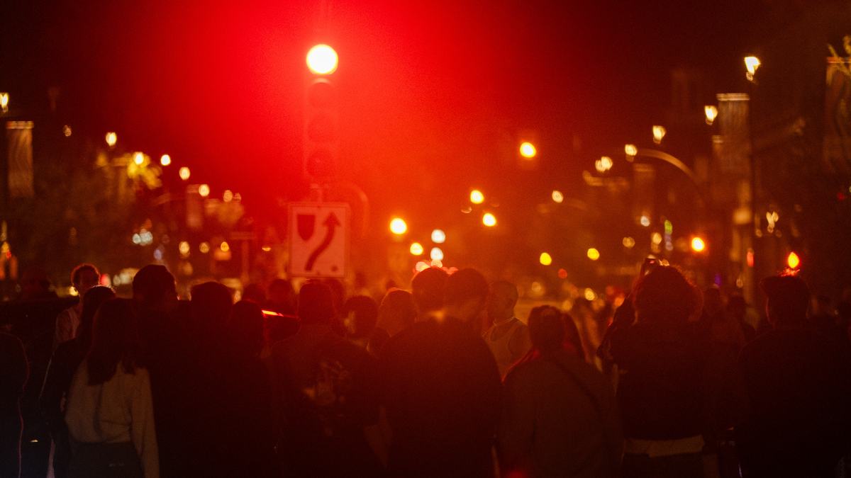 The crowd on Broadway under a red traffic light